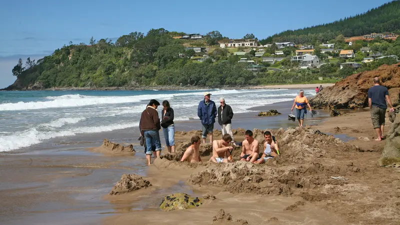 People digging their own hot pools in the sand at Hot Water Beach