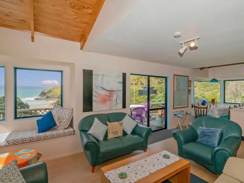 Living room with a cushioned window seat looking out to the sea